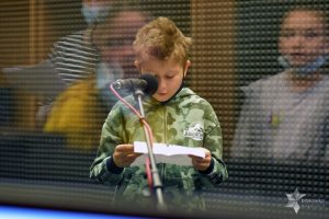 Uczestnik spotkania w studiu nagrań czyta tekst przy mikrofonie