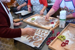 Kobiety stoją wokół stołu pełnego składników do pieczenia