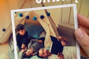 Plakat zachęcający do czytania. Widać dłoń trzymającą fotografię przedstawiającą mężczyznę czytającego książkę dwójce dzieci leżących obok niego w namiocie z materiału ozdobionym lampkami. W tle rozmyte zabawki na podłodze. Na plakacie znajduje się hasło „Czytaj chwilę” oraz tekst: „Dzieci nie czekają – dorastają. Łap chwile, które zostaną z nami na zawsze. Czytaj!”